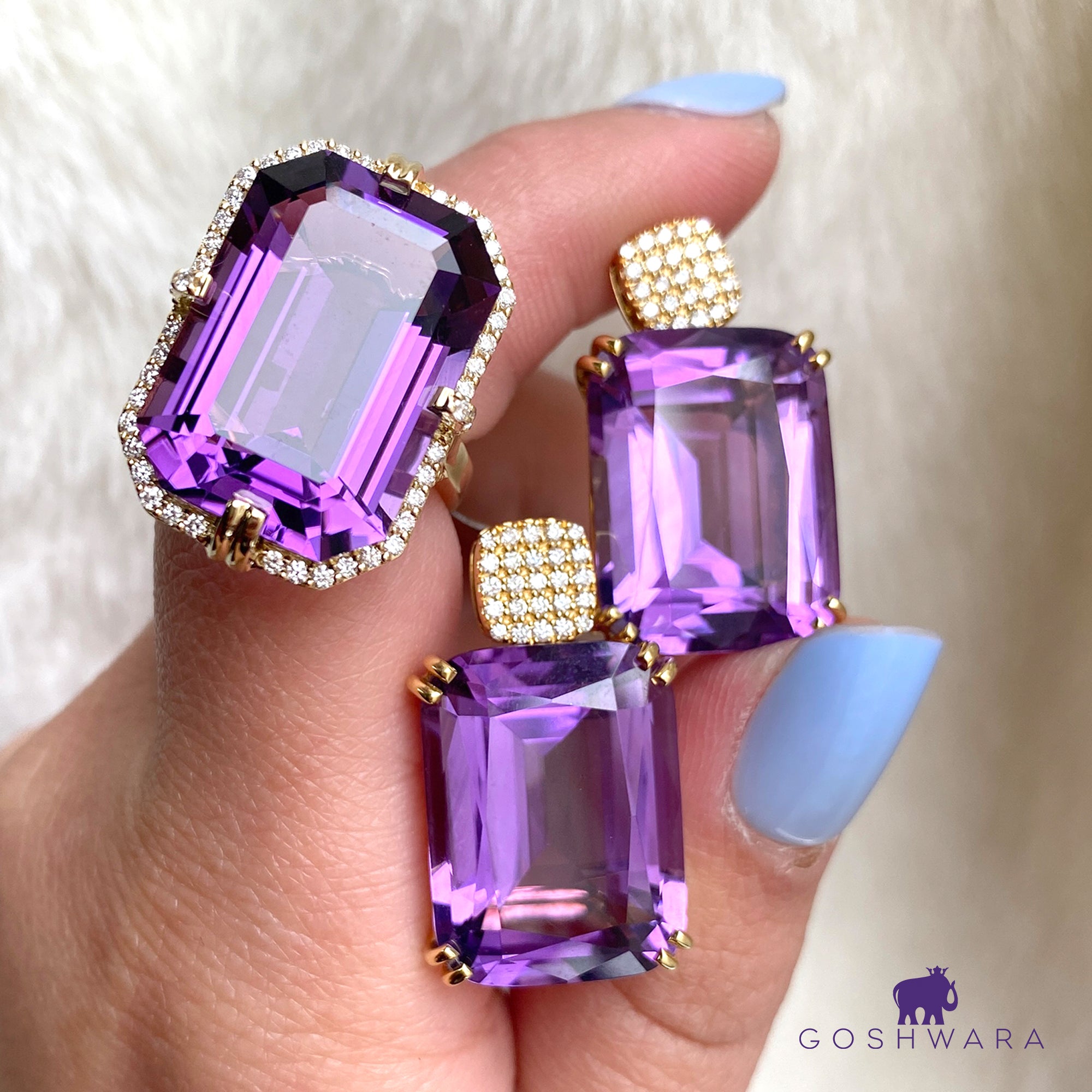 Purple gemstone earrings with gold accents held by a hand against a white background and Goshwara brand logo