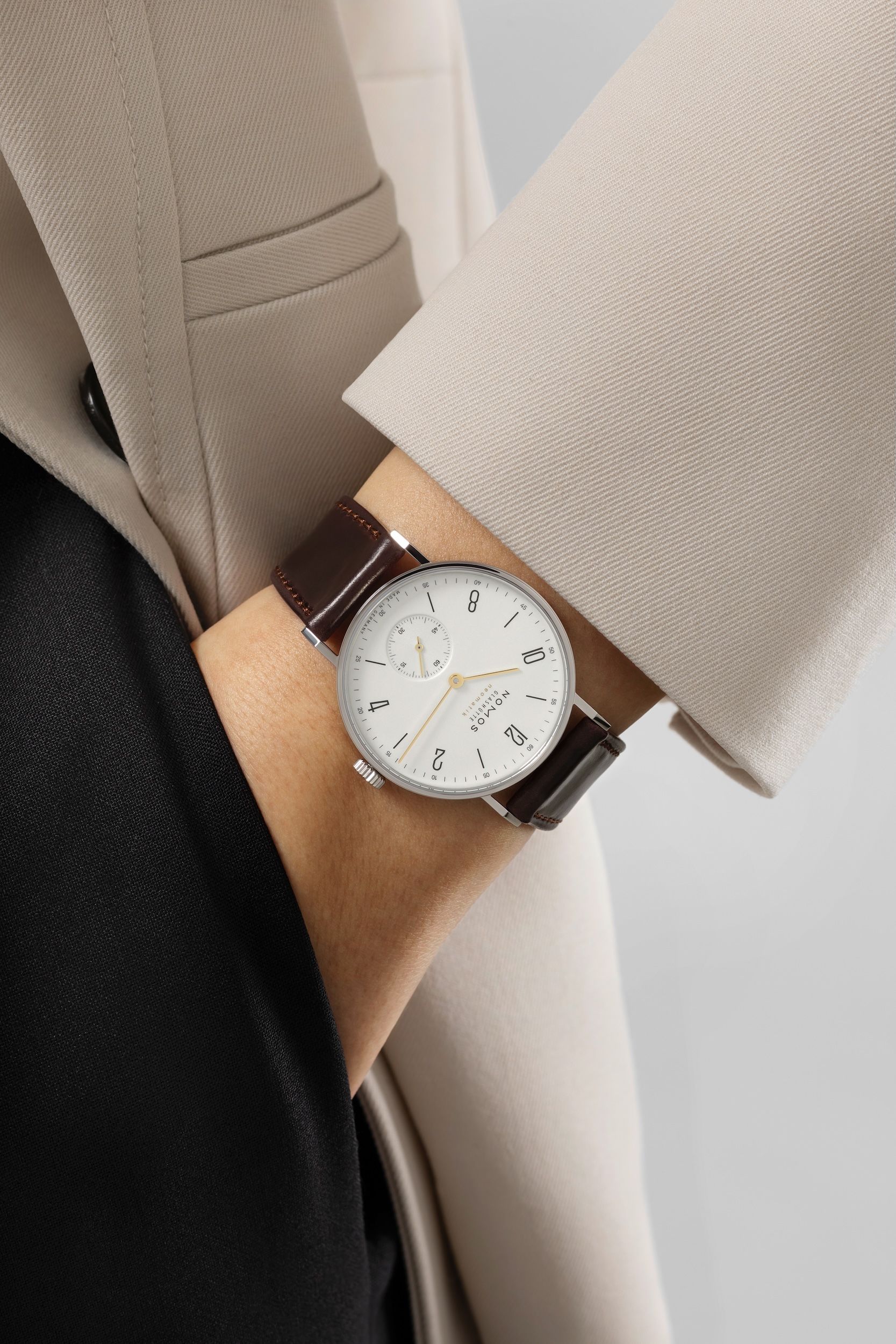 Person wearing a watch with a neutral background