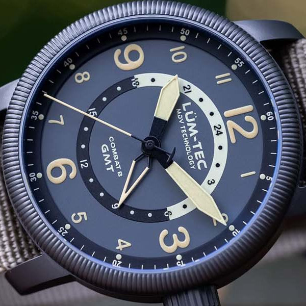 Watch with a grey strap and navy blue dial on a blurred background