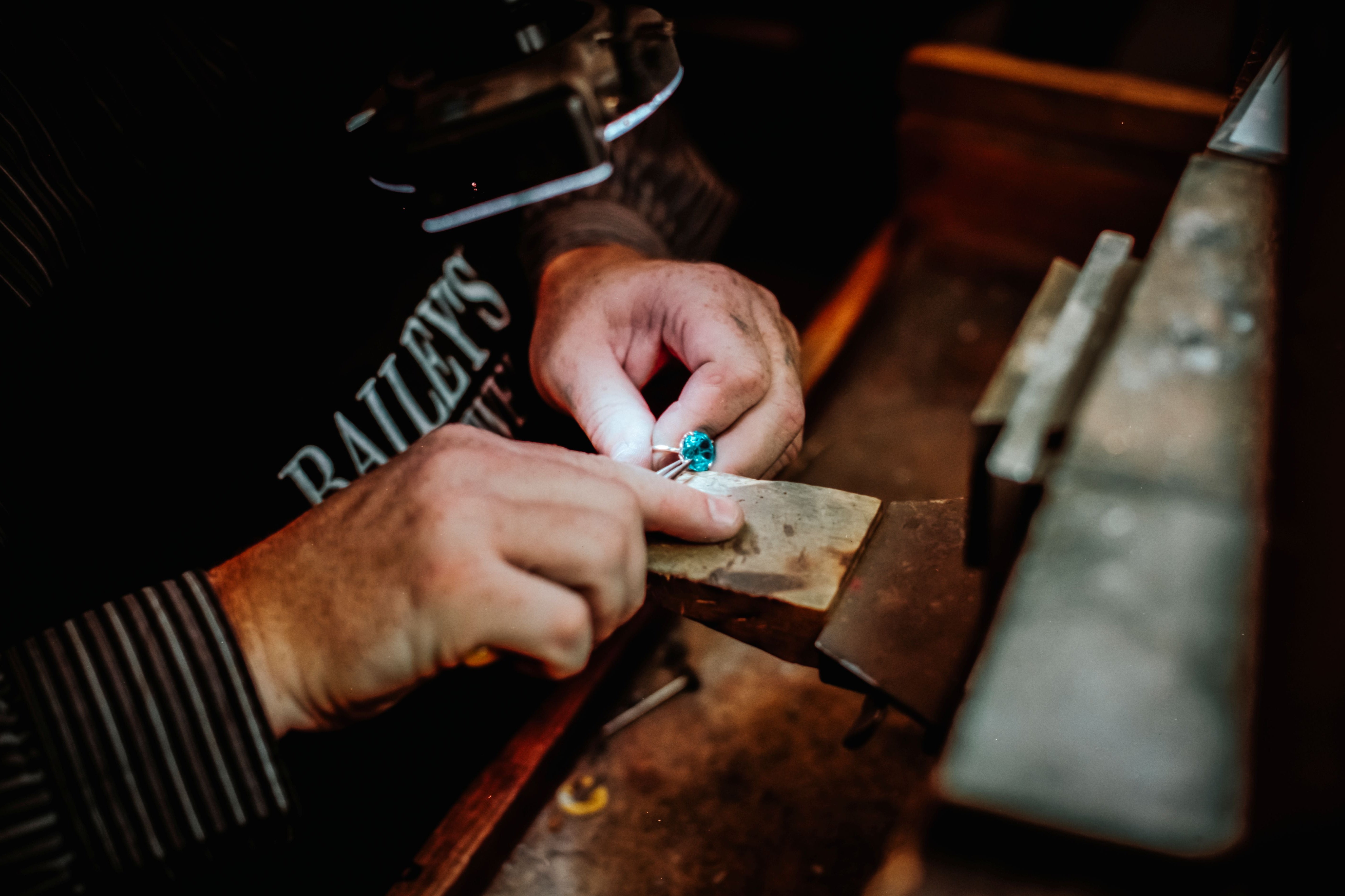 Person working with a gemstone on a wooden anvil