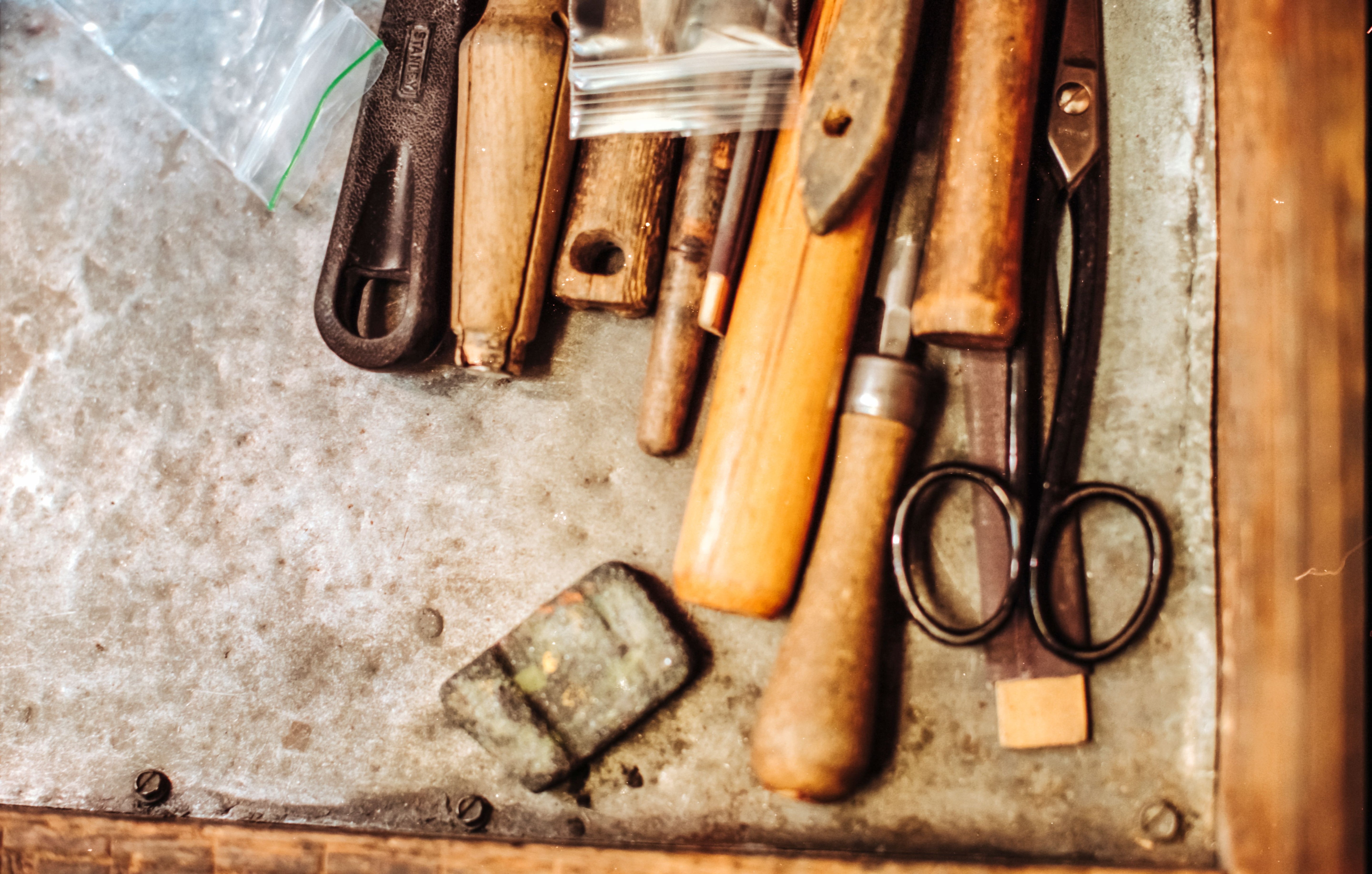 Vintage tools including scissors and chisels on a metal surface