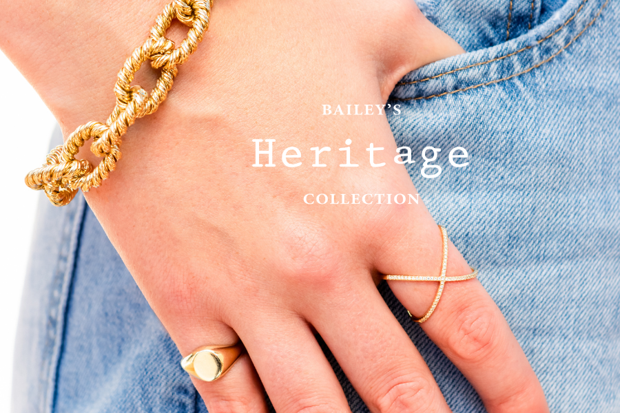 Hand wearing gold jewelry with 'Bailey's Heritage Collection' text overlay