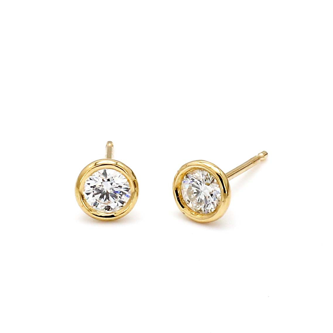 Pair of gold diamond stud earrings on white background
