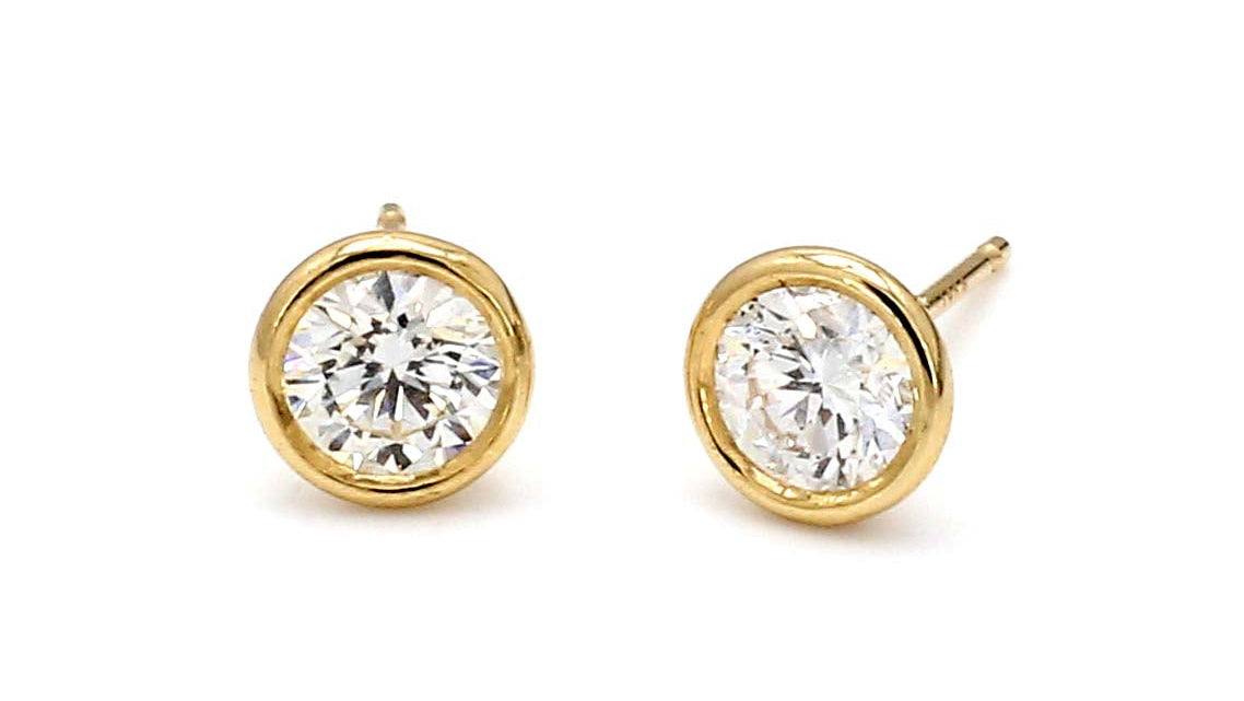 Gold earrings with clear gemstones on a white background