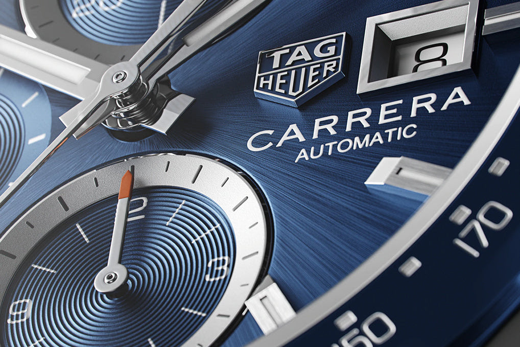 Close-up of a Tag Heuer Carrera watch face with blue gradient and metallic accents.