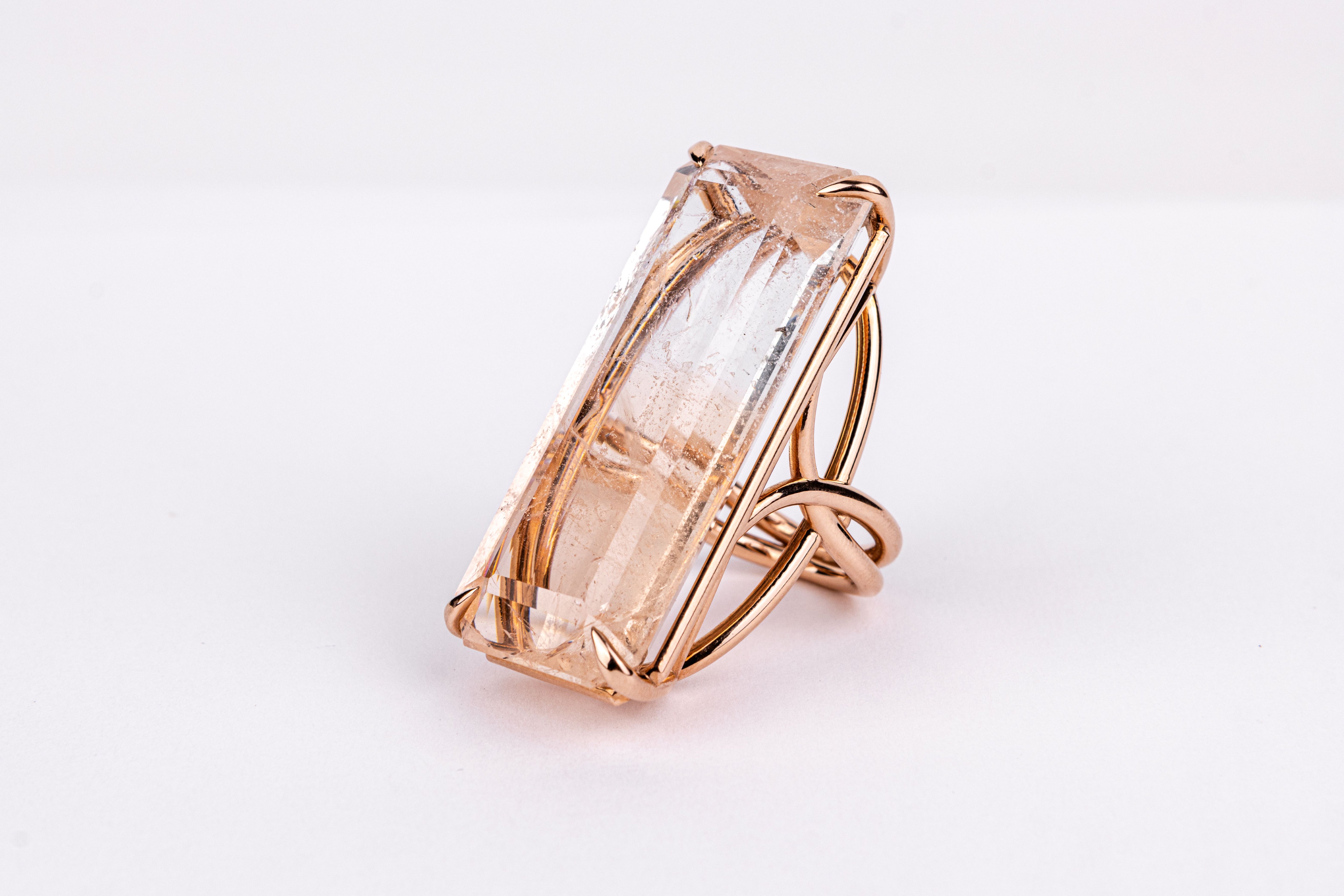 Rose gold ring with a large rectangular gemstone on a white background