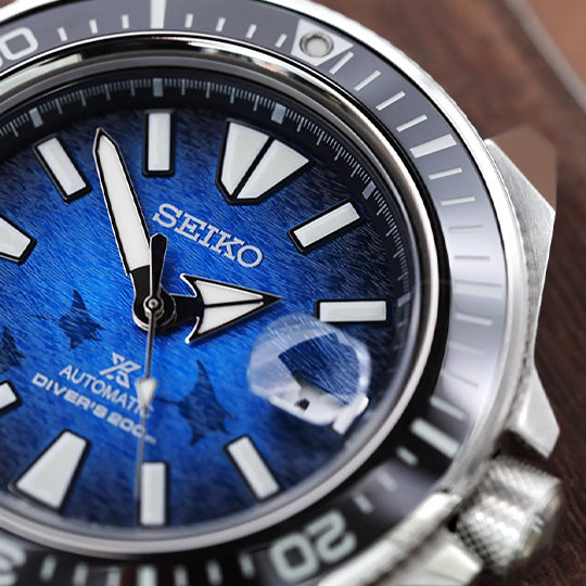 Close-up of a Seiko watch with a blue face and silver case.
