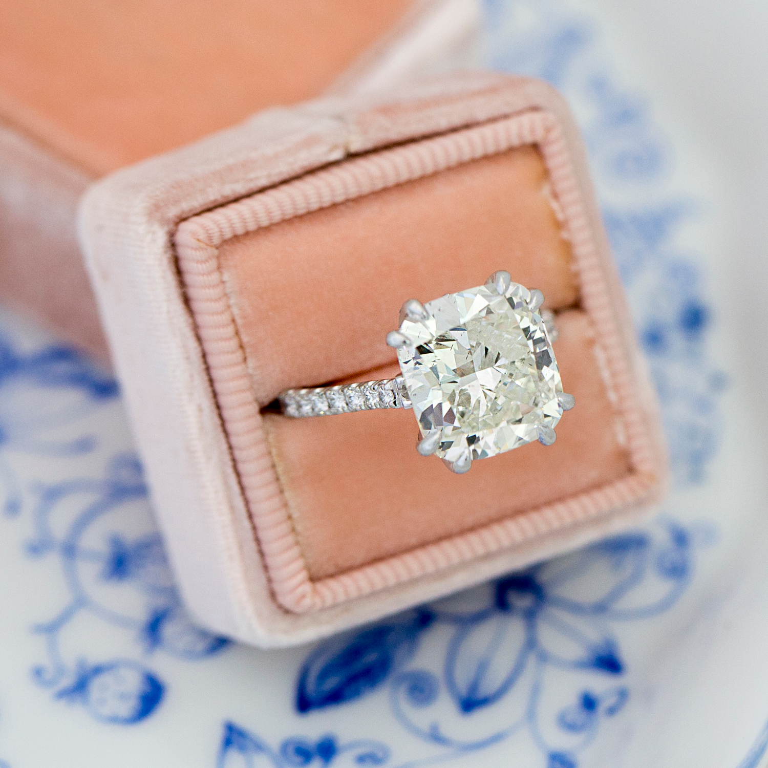 Diamond ring in a pink box on a decorative blue and white background