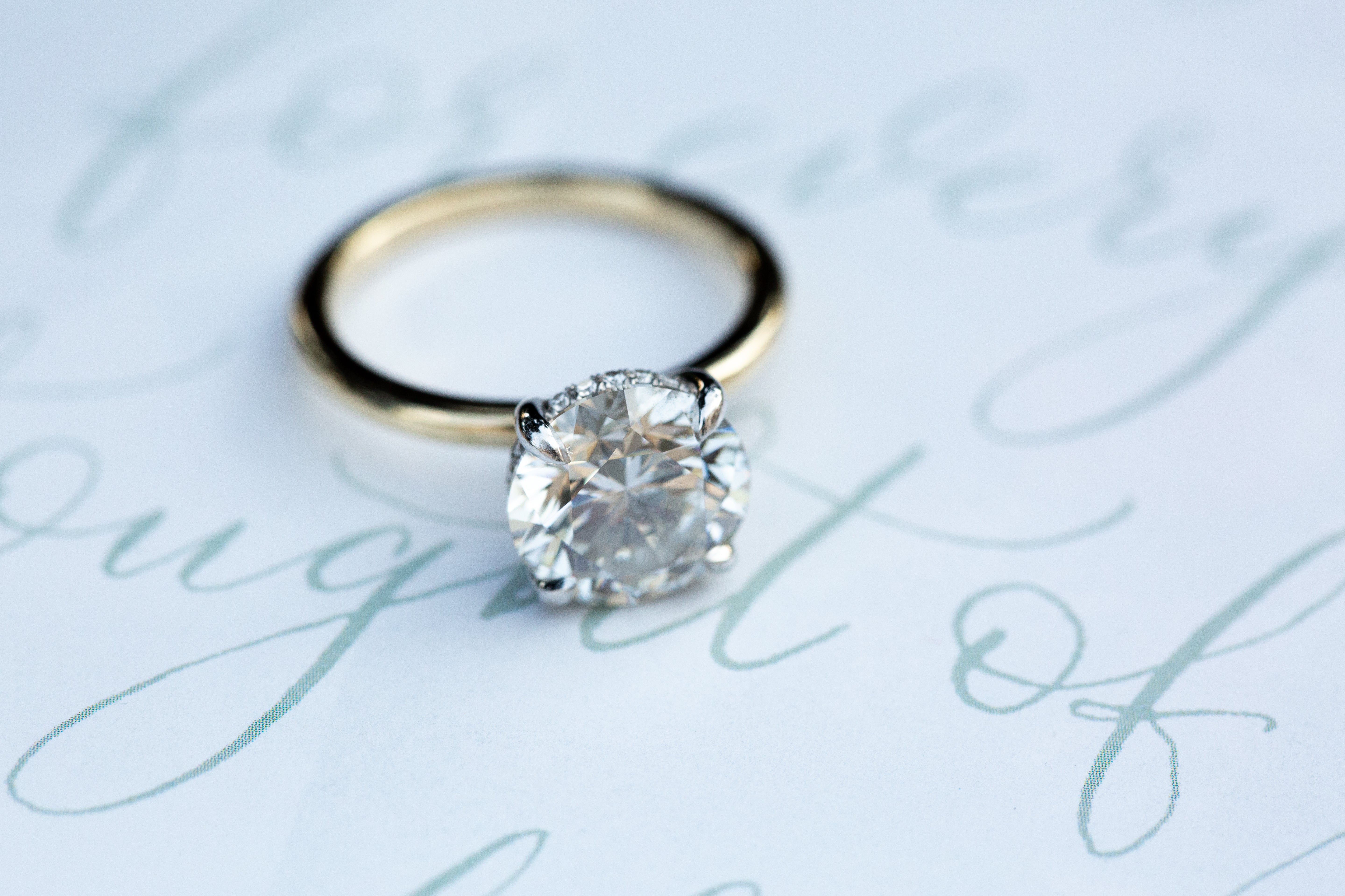 Diamond ring on a light background with cursive text