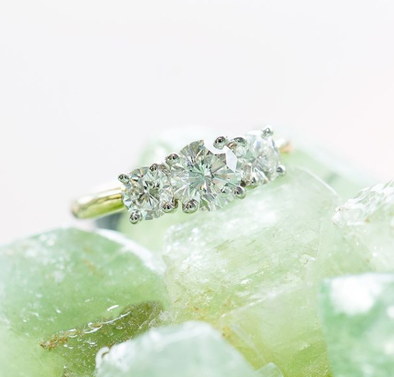 Diamond ring on a green stone with a white background