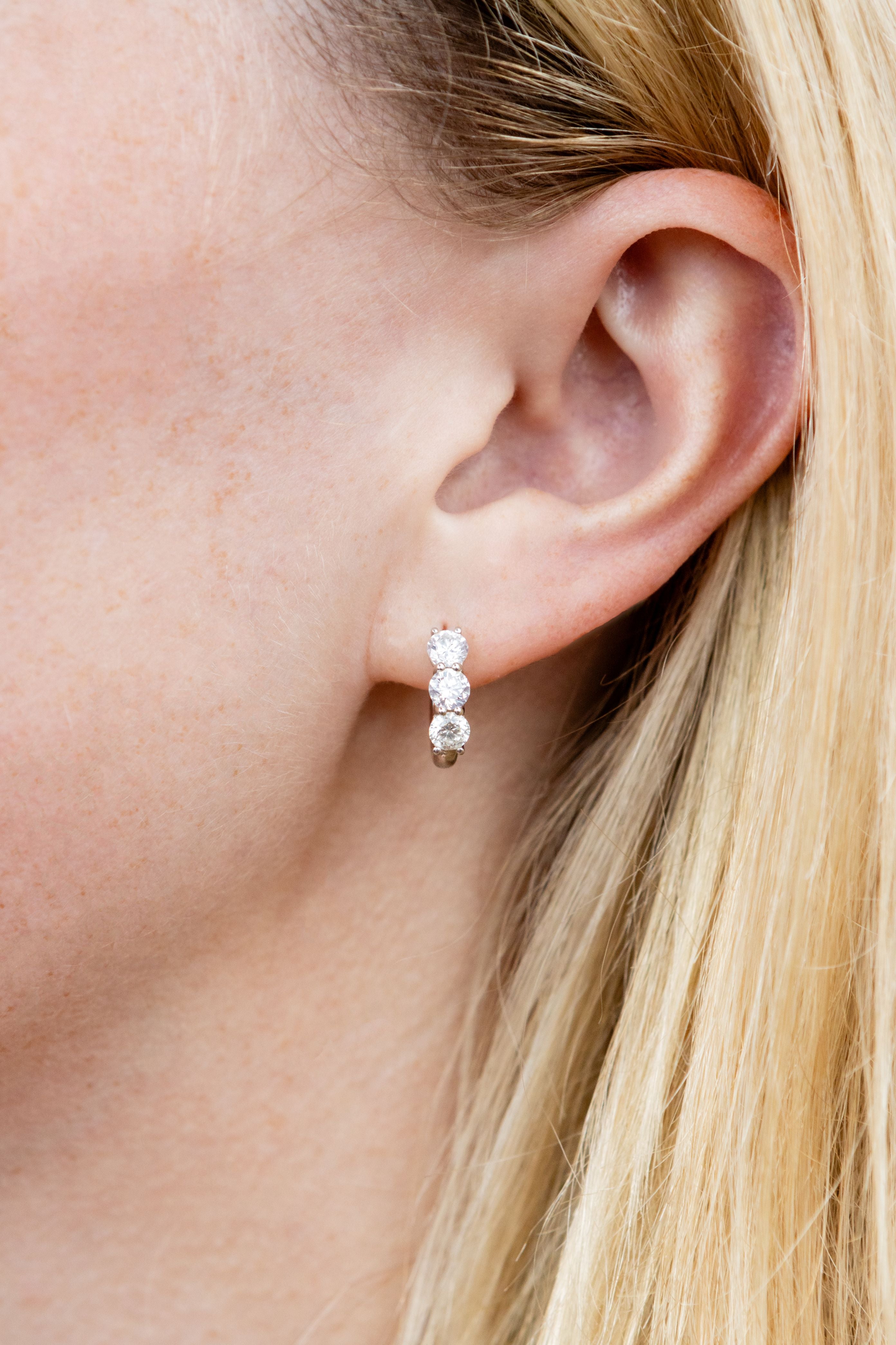 Close up of diamond earring on ear with blonde hair