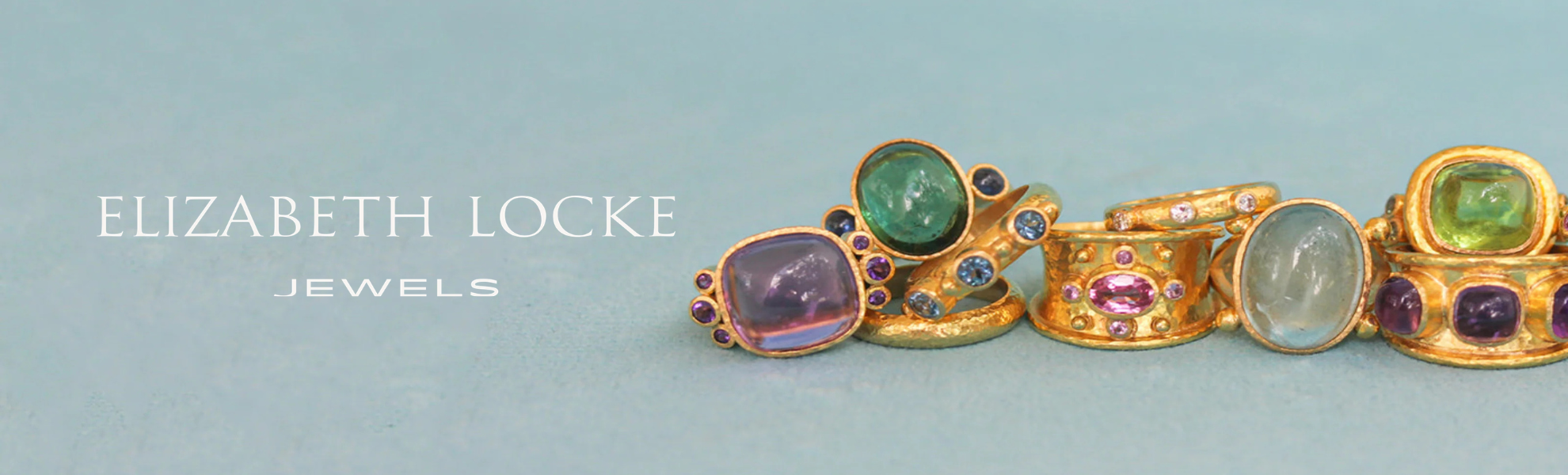 Gold jewelry with colorful gemstones on a light blue background, featuring the brand 'Elizabeth Locke'.