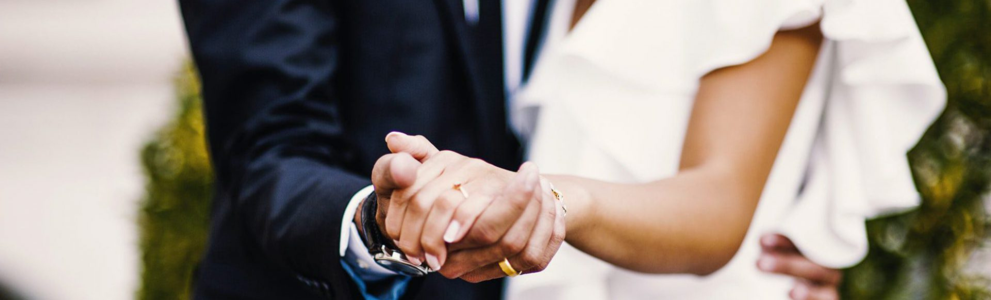 Two people holding hands with a blurred background