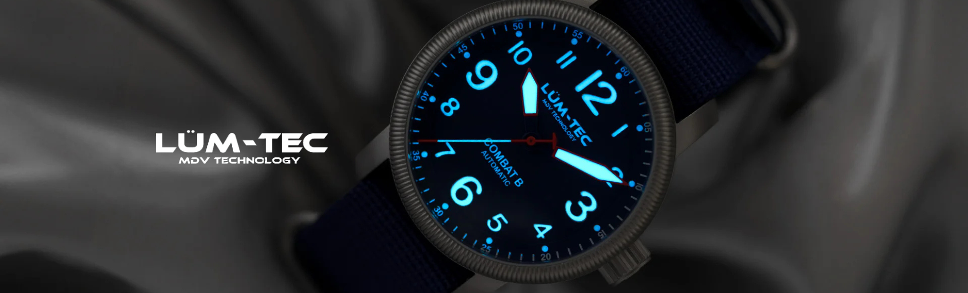 LUM-TEC watch with glowing blue face on a dark background