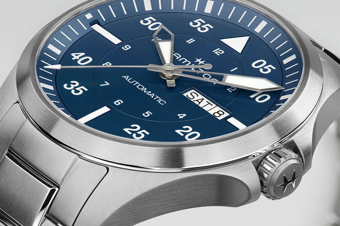 Silver watch with a blue dial on a light gray background