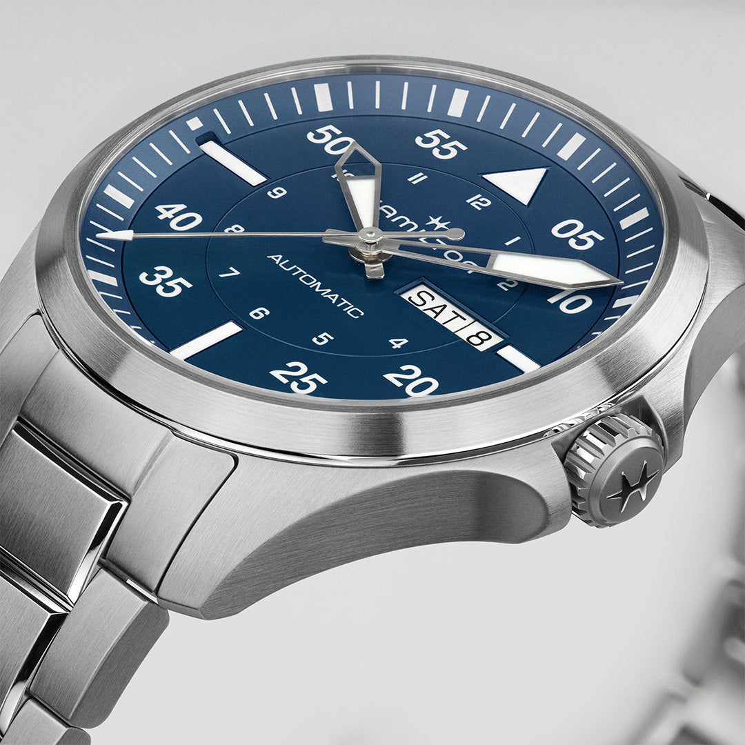 Silver watch with a blue dial on a light gray background