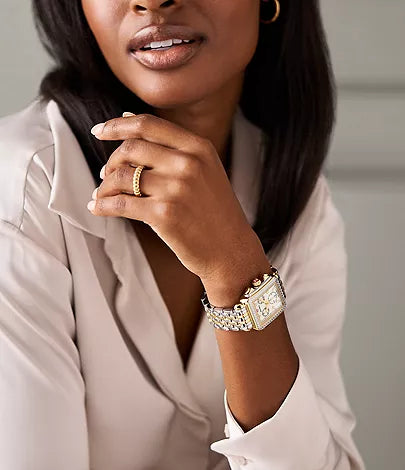 close up of watch on woman's wrist with a neutral background