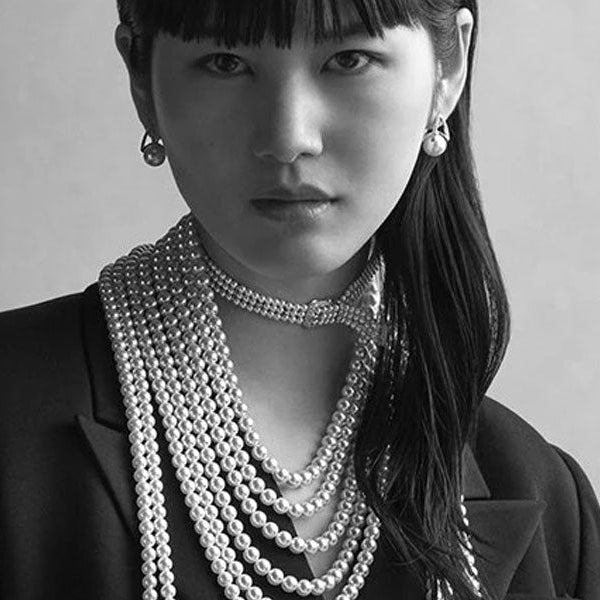 Woman wearing Mikimoto jewelry with the brand name displayed