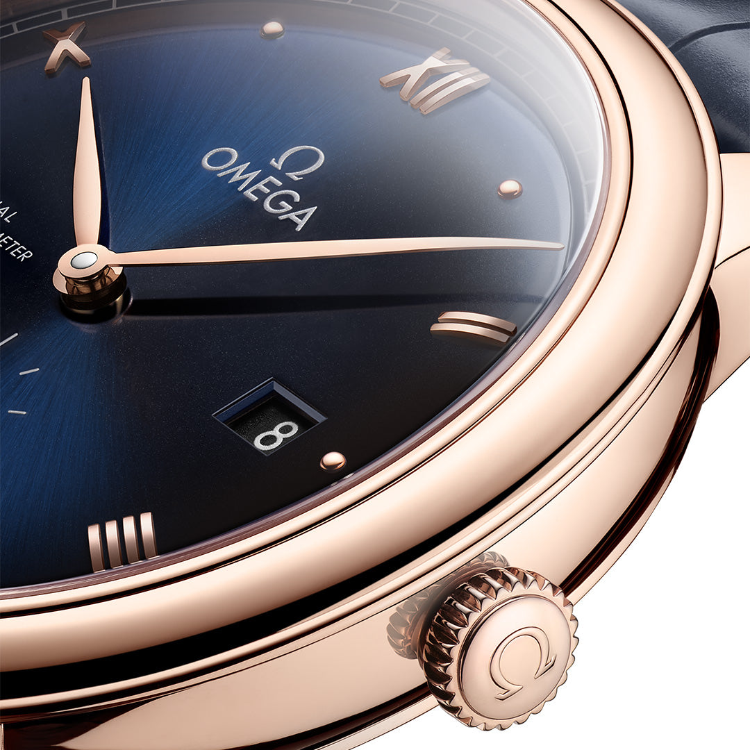 Close-up of an Omega watch with a blue face and rose gold case.