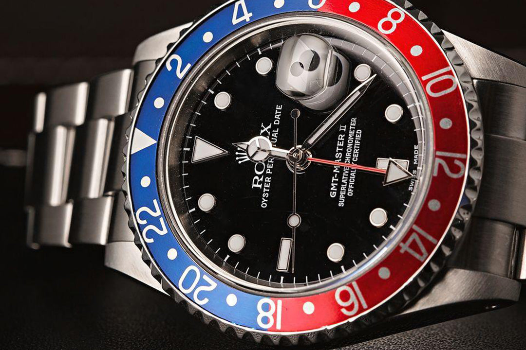 Rolex watch with a distinctive red, blue, and silver design on a dark background