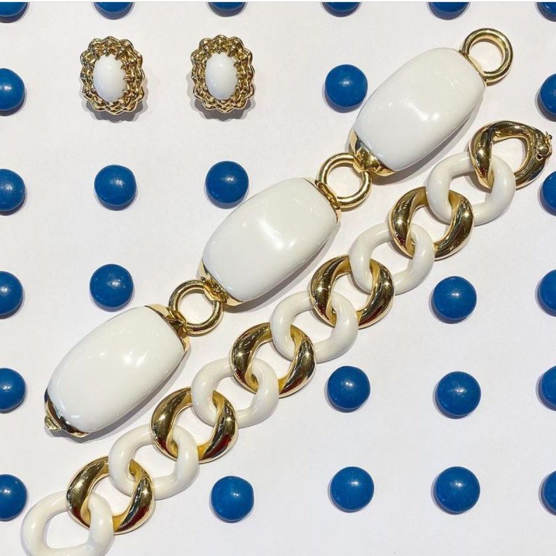 White and gold chain necklace with matching earrings on a white background with blue accents.