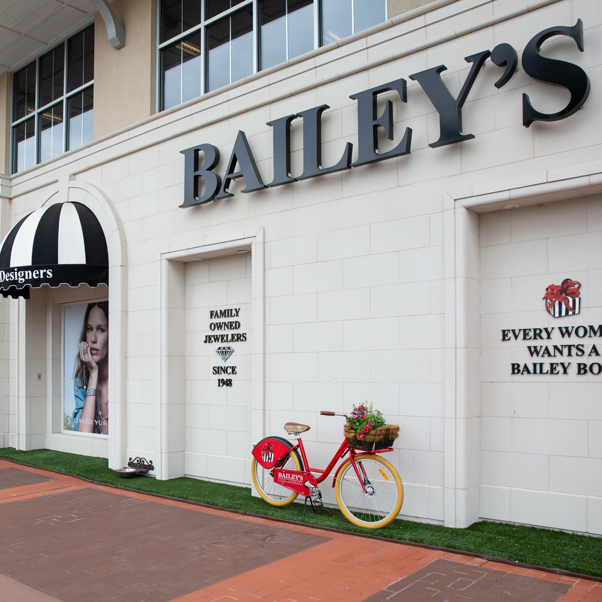 Bailey's jewelry store exterior with a red bicycle and promotional signs.