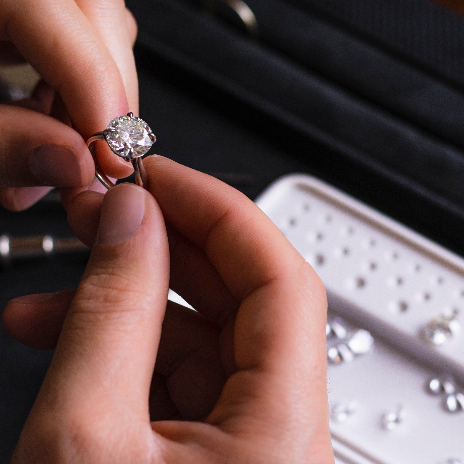 Close-up of hands holding a diamond ring with a blurred background
