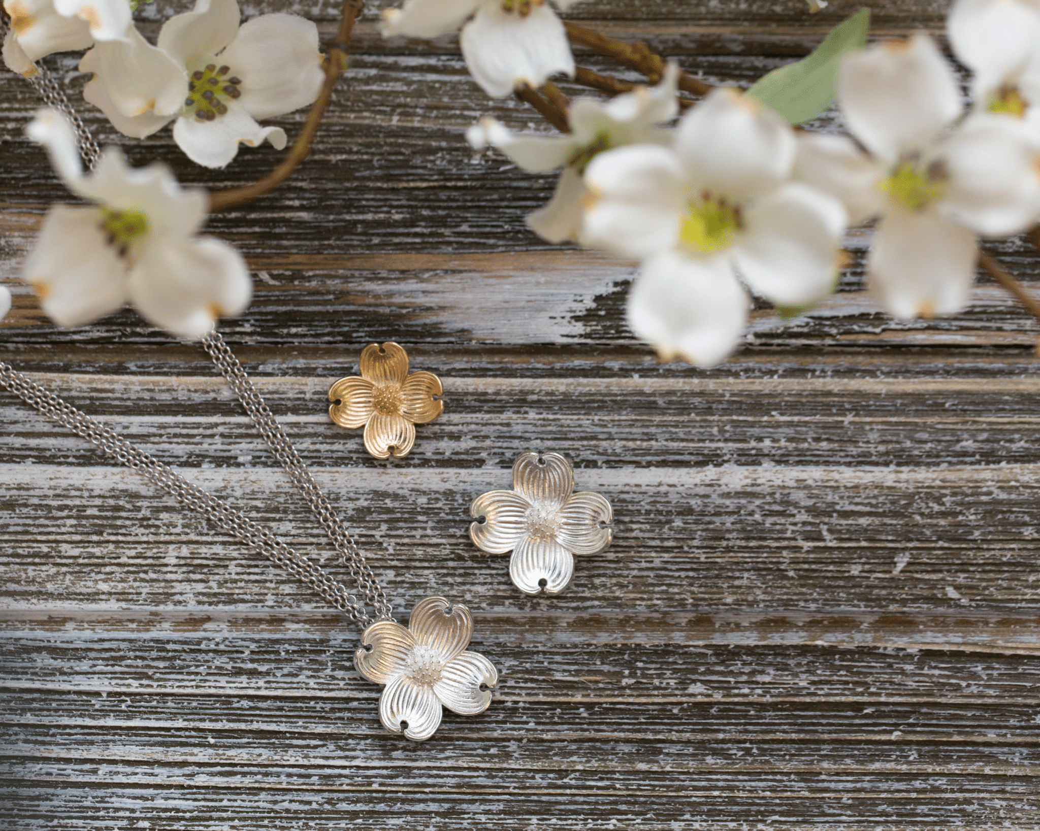 Floral jewelry set on a wooden surface with white flowers