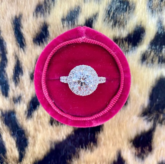 Diamond ring in a pink velvet box on a leopard print background