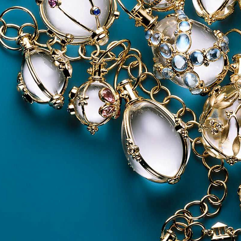 Gold necklace with various pendants on a blue background