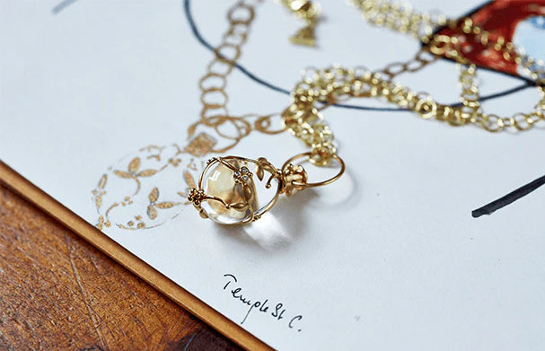 Gold necklace with a pendant on a textured surface