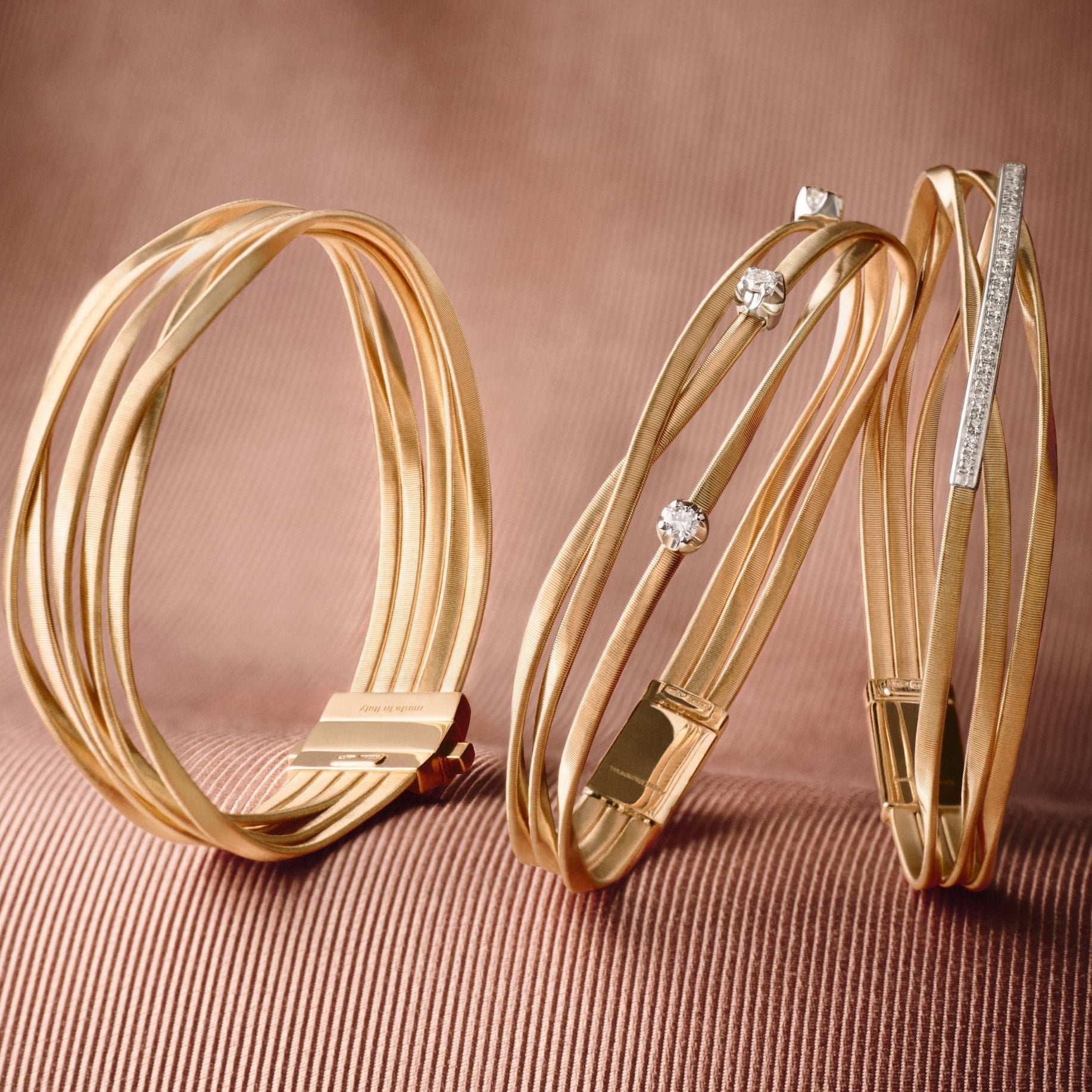 Gold hoop earrings with embedded diamonds on a brown textured background