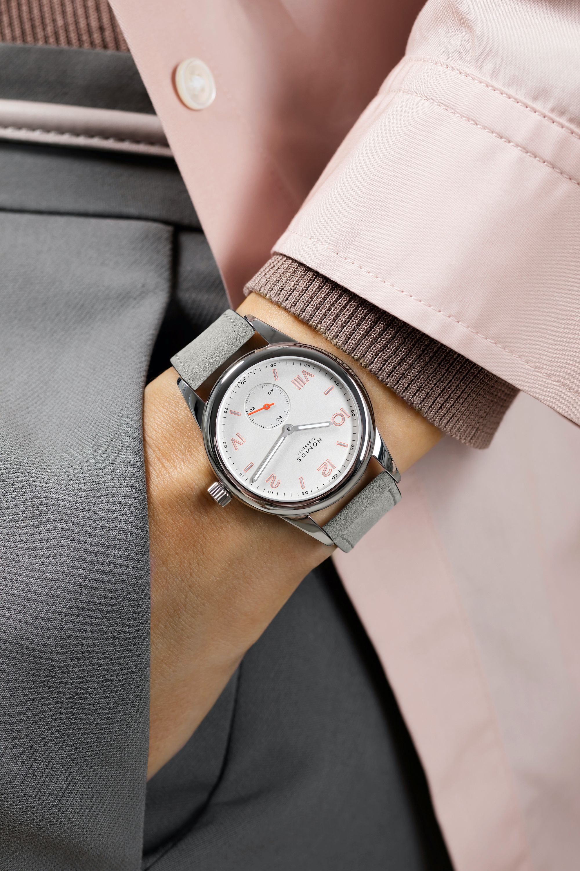 Close-up of a wrist wearing a watch with a neutral background