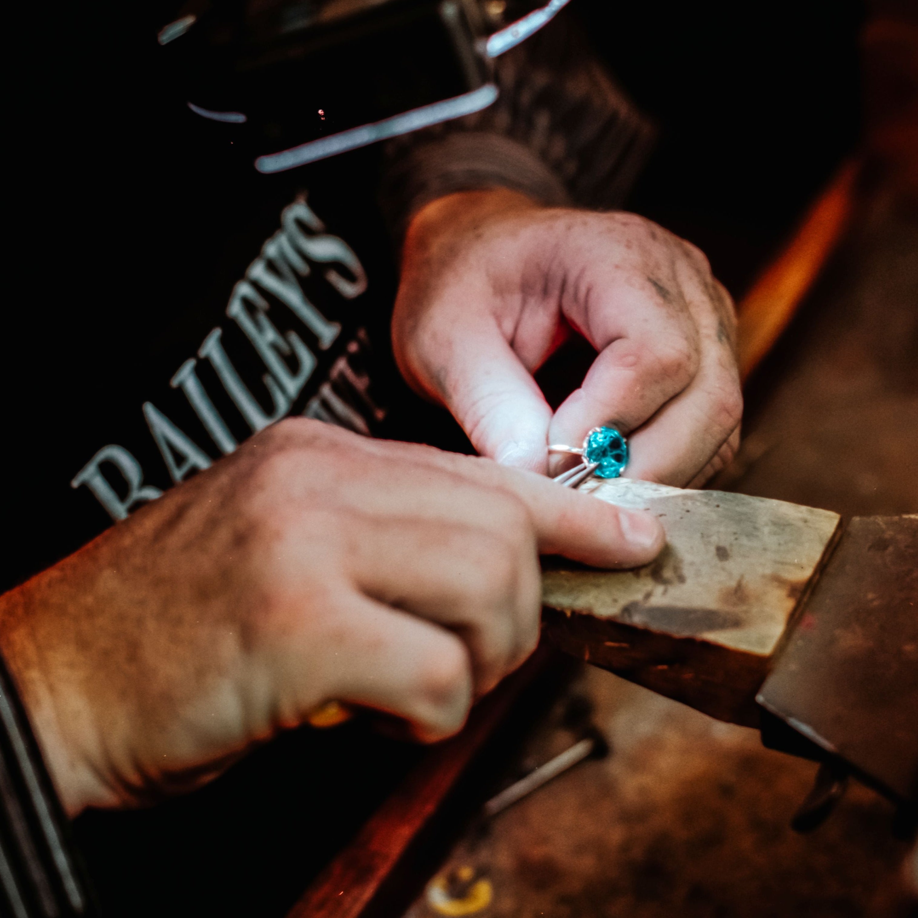 Person working with a gemstone on a wooden anvil