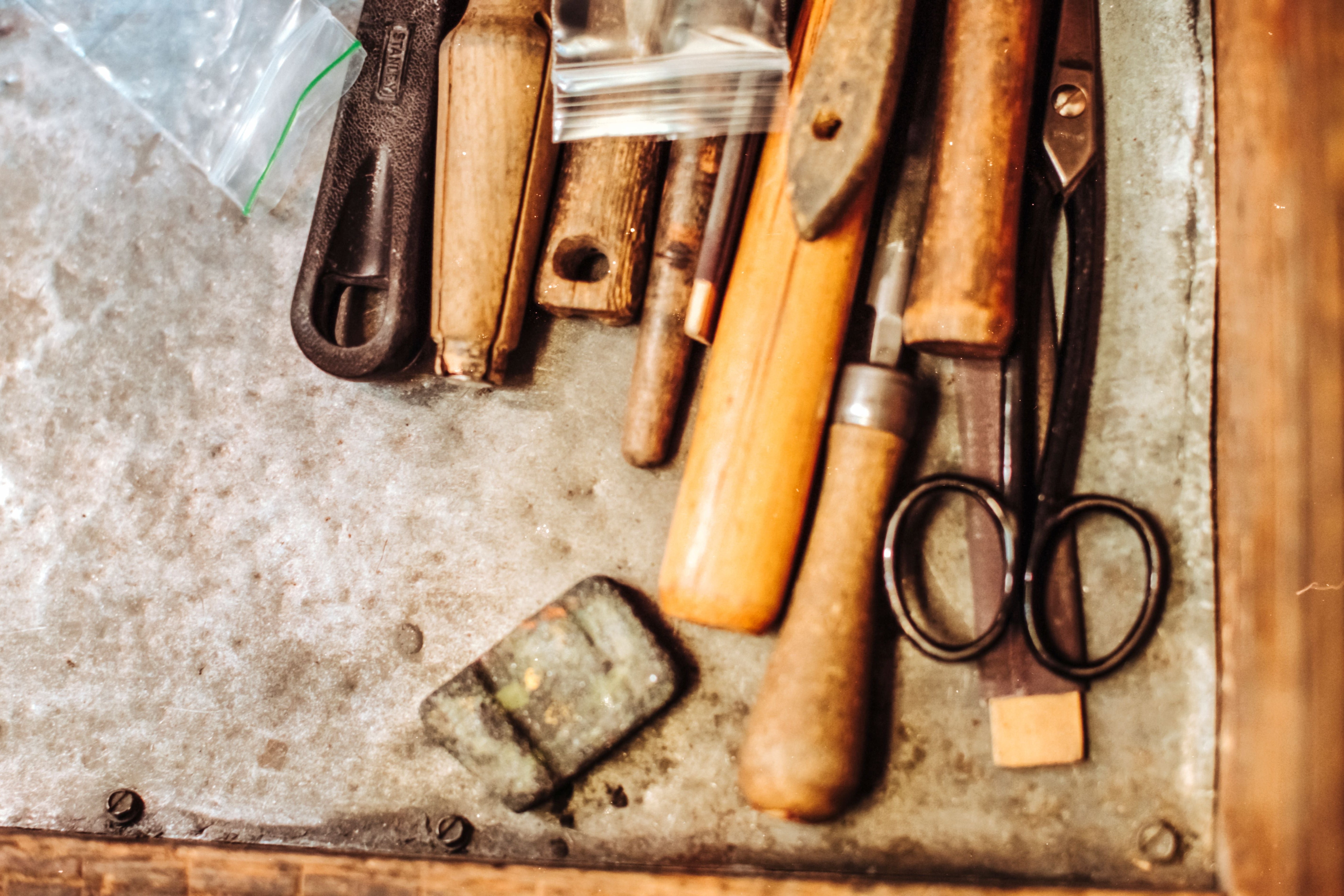 Vintage tools including scissors and chisels on a metal surface