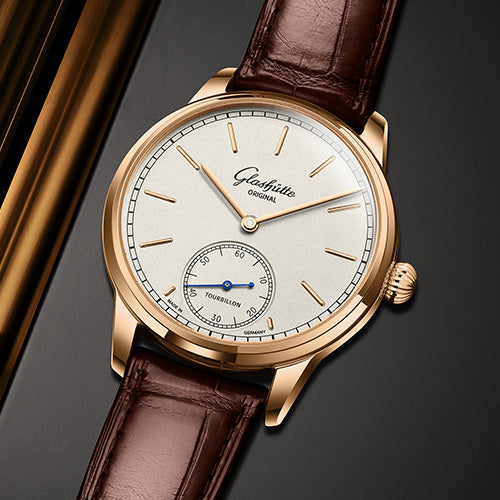 Luxury watch with brown leather strap and gold casing on a dark background