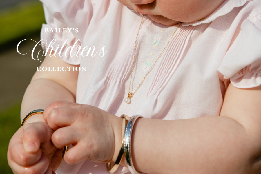 Baby wearing gold bracelets with 'Bailey's Children's Collection' text overlay.