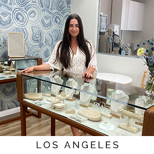 Woman standing behind a glass display case with jewelry in a store setting, labeled 'Los Angeles'.