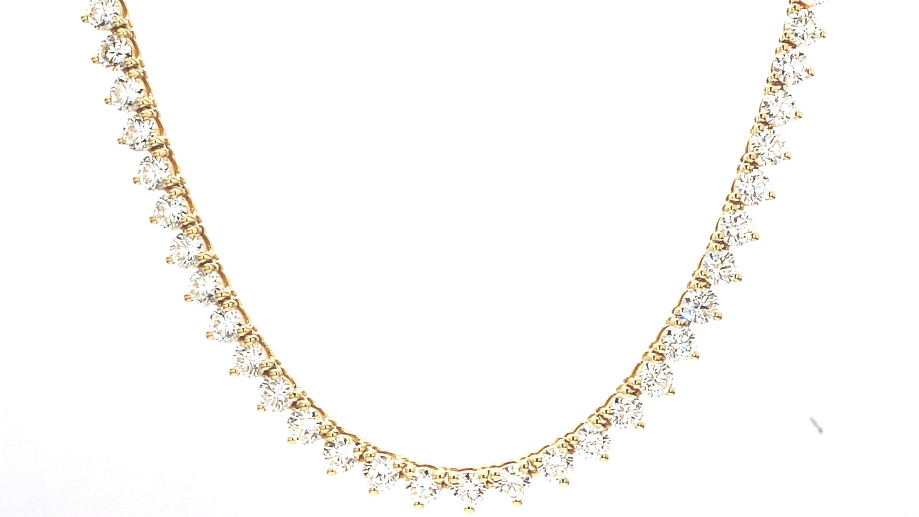 Gold necklace with clear stones on a white background