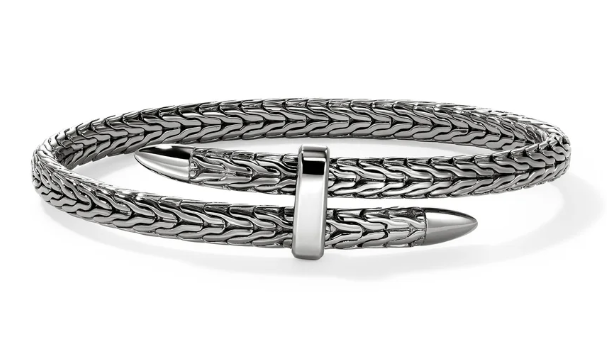 Silver bracelet with intricate design on a white background