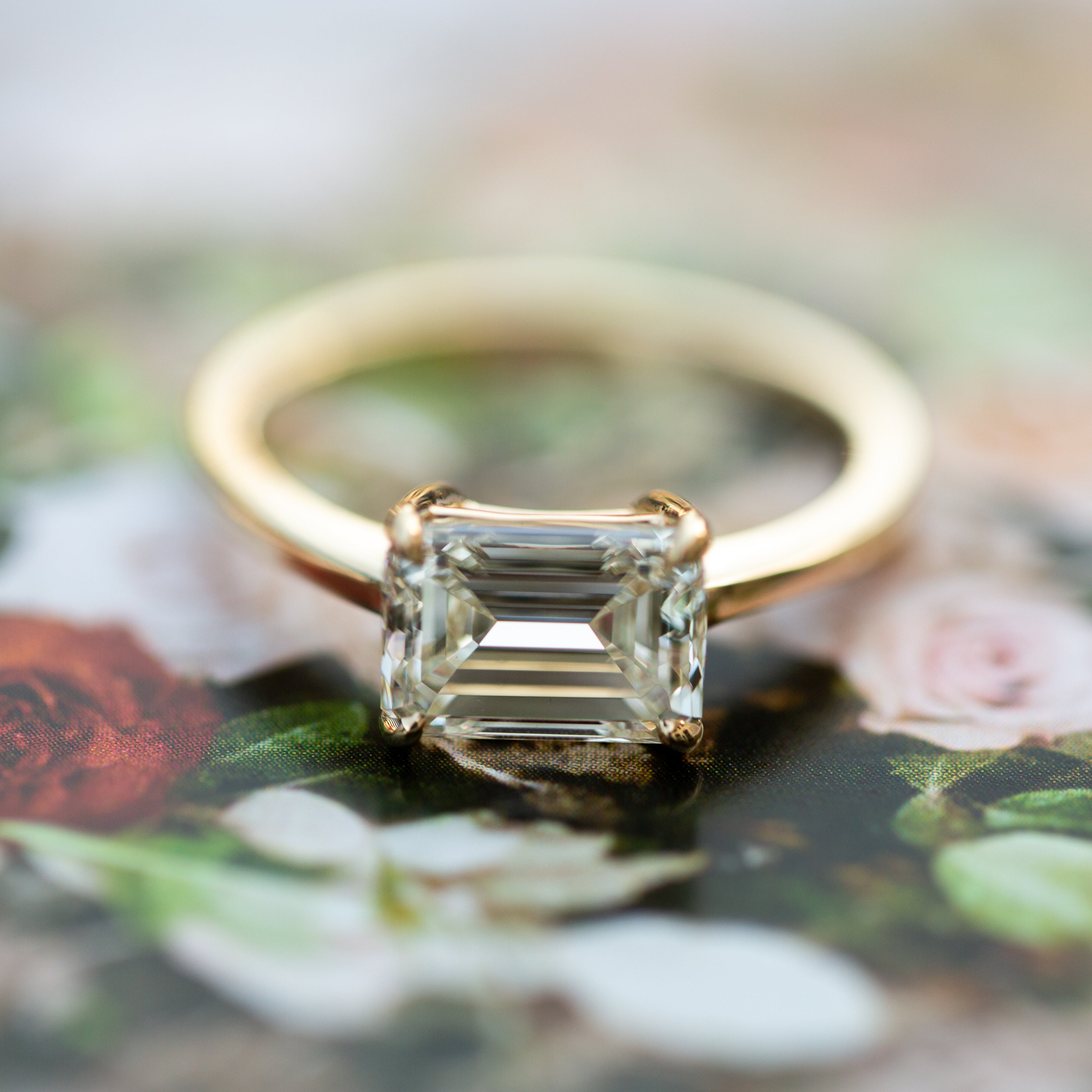 Gold ring with a diamond on a floral background