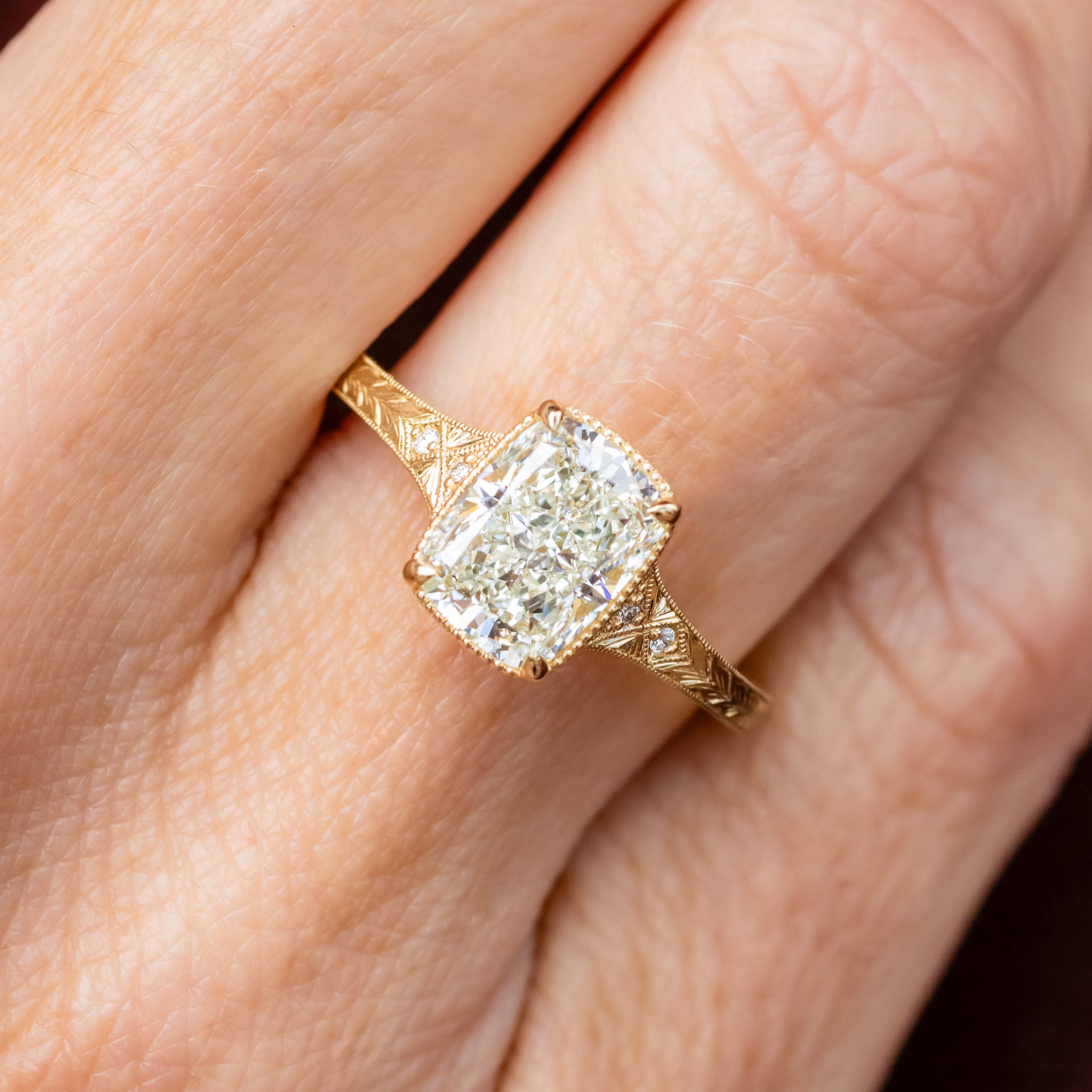 Gold ring with a diamond on a person's finger