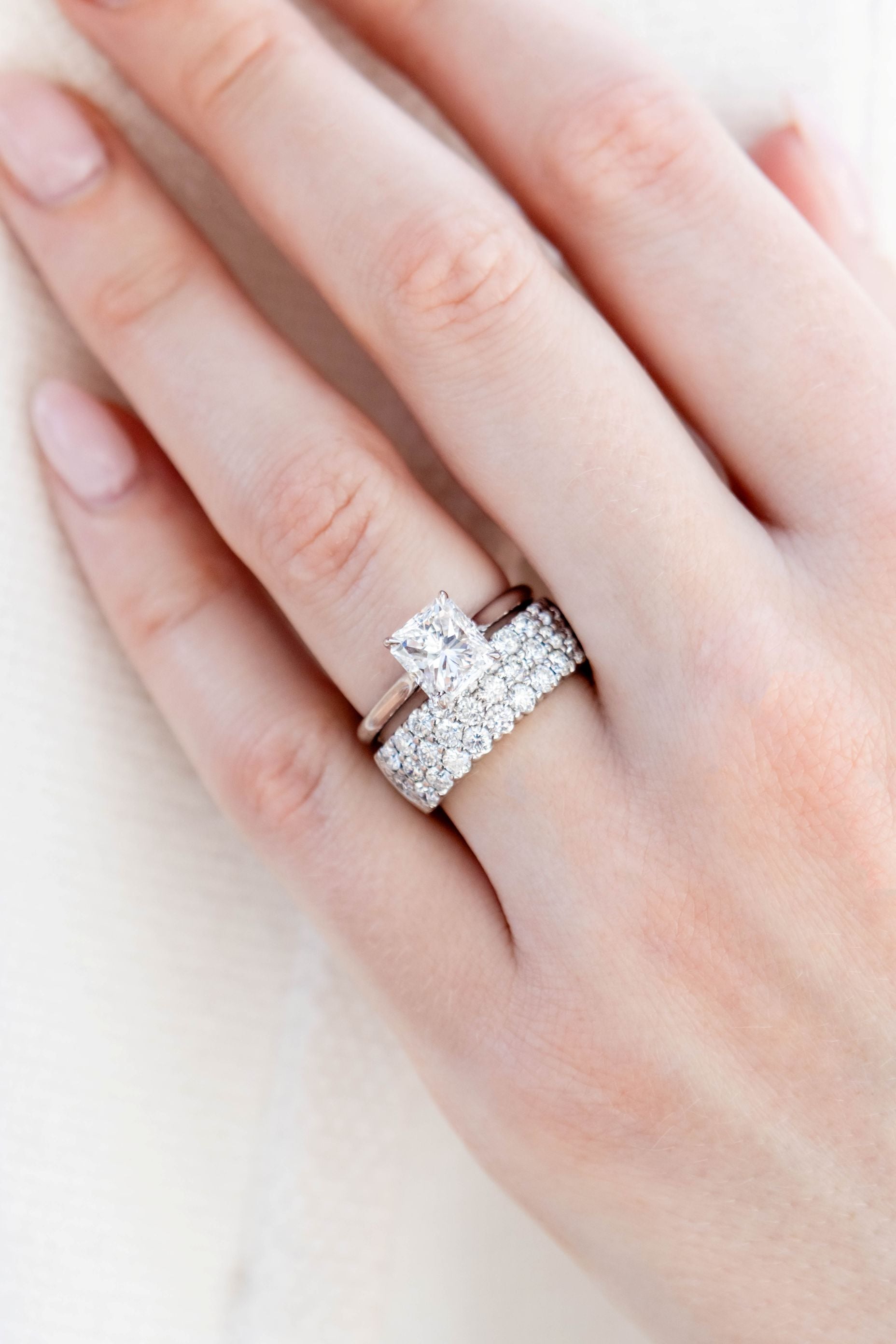 hand wearing diamond rings on a white background
