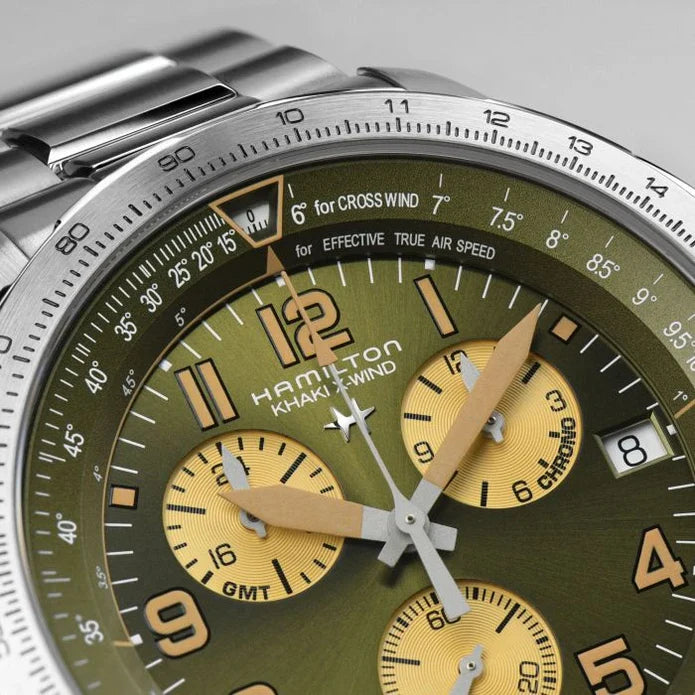 Close-up of a Hamilton Khaki Wind chronograph watch with a green dial, yellow subdials, and a silver stainless steel case and bracelet.