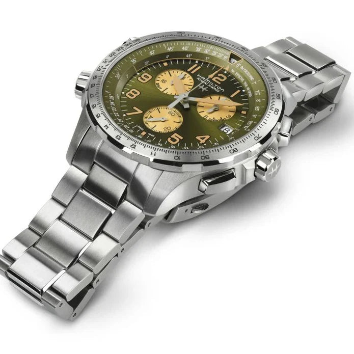 Silver watch with a green face on a white background
