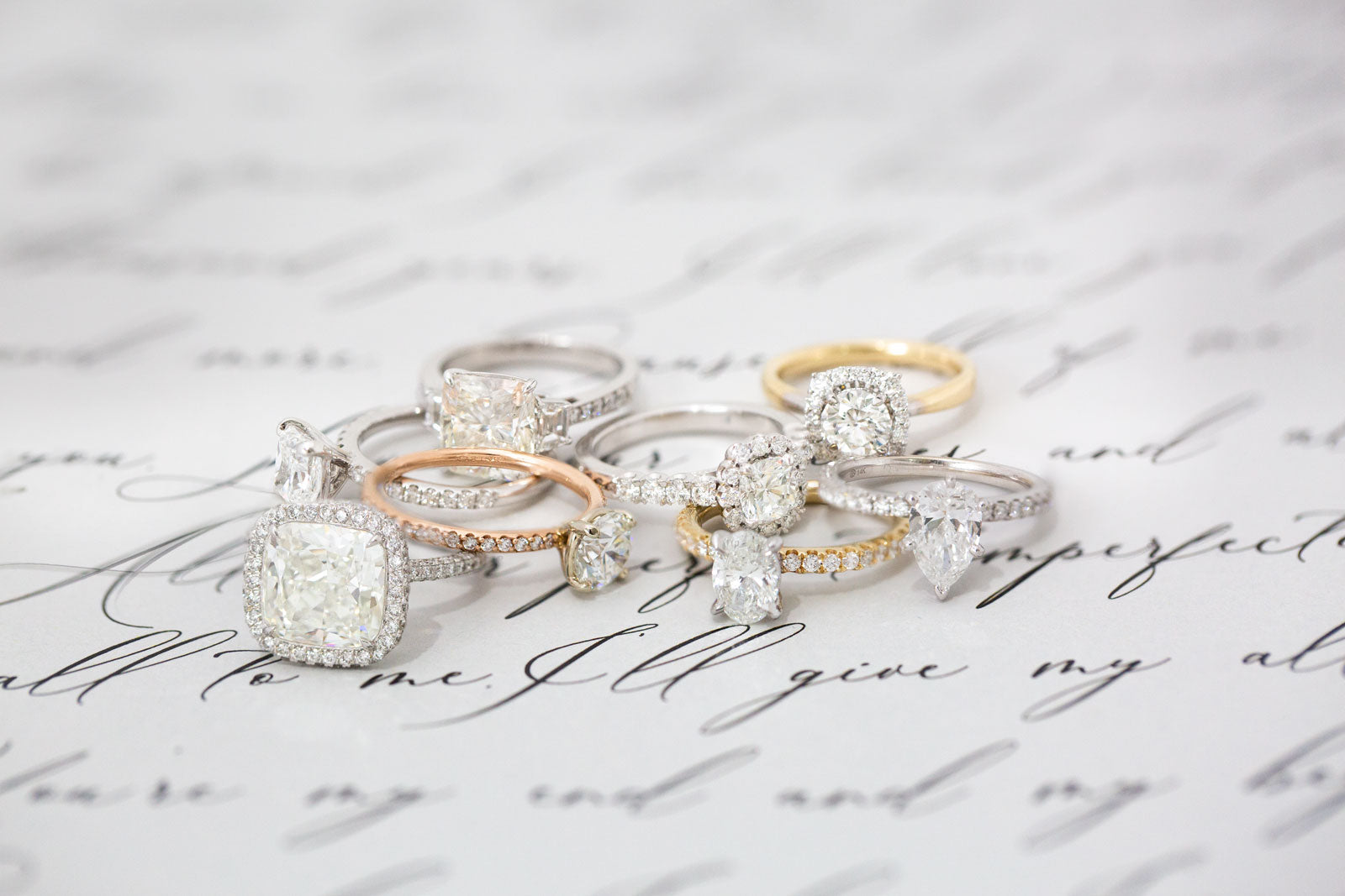 Collection of rings on a textured surface with cursive text