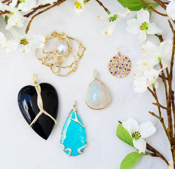 Collection of various pendants on a white surface with floral elements