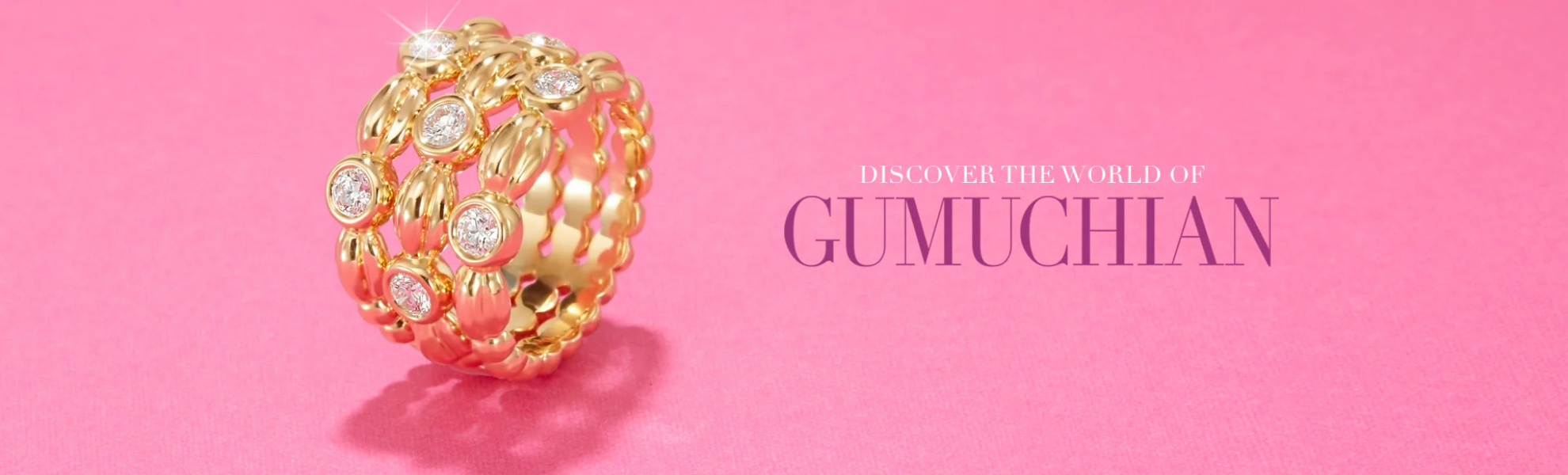 Gold bracelet with gemstones on a pink background, featuring the brand 'Gumuchian'.