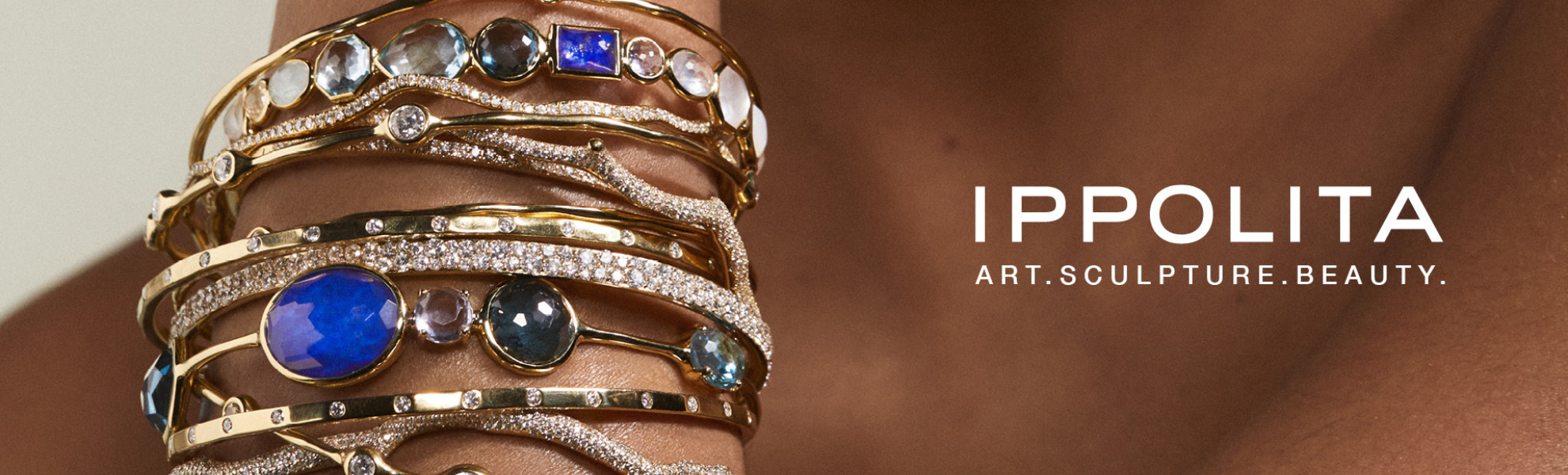 Ippolita gold bracelets with gemstones on a wrist, brand name visible