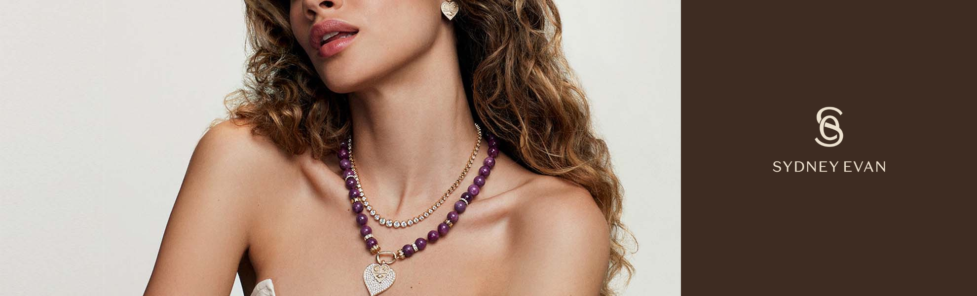 Woman wearing a necklace with Sydney Evan logo